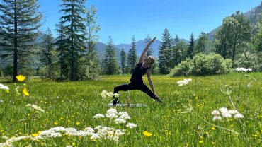 Bärbel von YOGAMOUR praktiziert Yoga in einer Sommerwiese